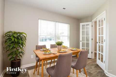 A dining room with a wooden table and chairs.