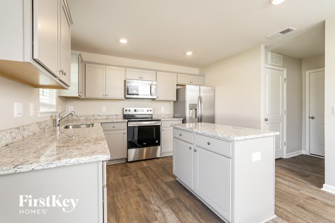 A kitchen with a marble countertop and stainless steel appliances.