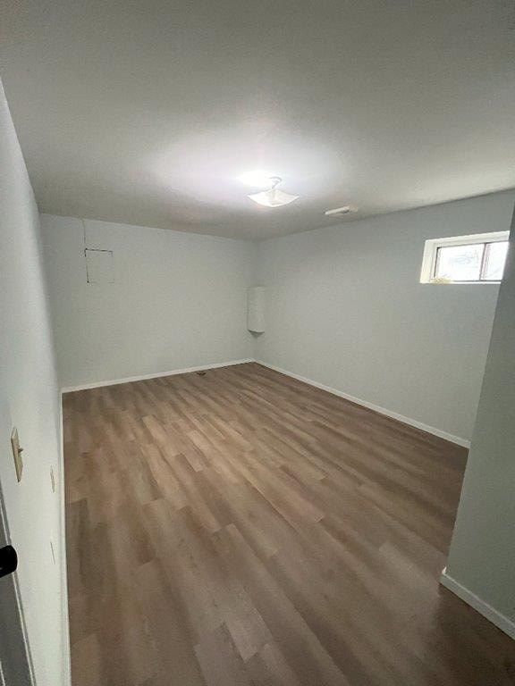 A room with wooden flooring and a window.