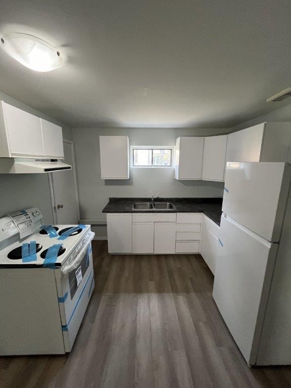 A small kitchen with white appliances and wood floors.