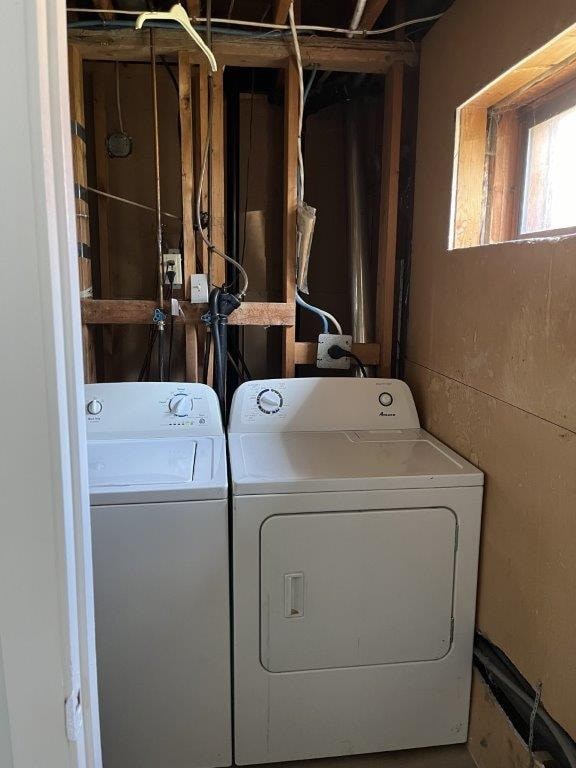 A washer and dryer in a room with unfinished walls.