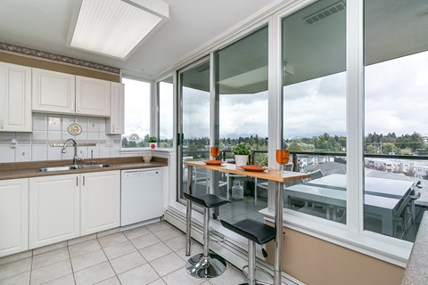 A kitchen with a table and chairs in front of a window.