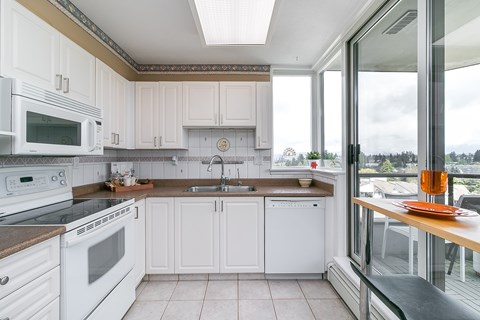 A kitchen with white appliances and cabinets.