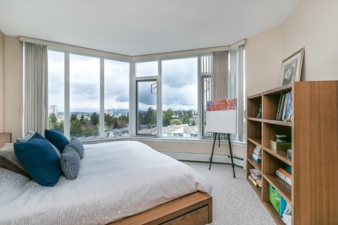 A bedroom with a large bed and a bookshelf.