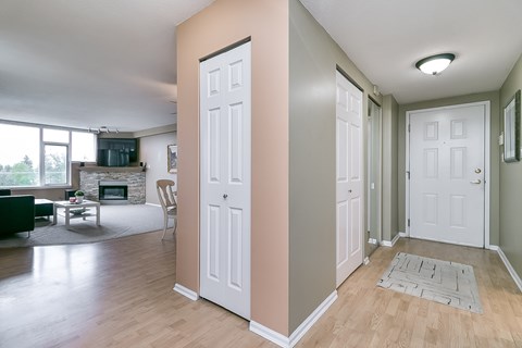 A white door is in a hallway with a rug on the floor.