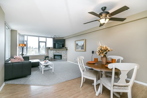 A living room with a fireplace and a dining table set for four.