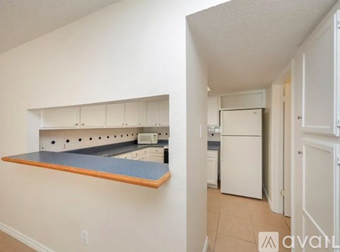 A kitchen with white cabinets and a blue countertop.