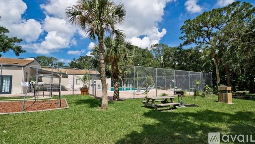 A park with a picnic table and a playground.