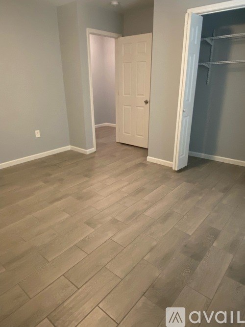 A room with a wooden floor and a white door.