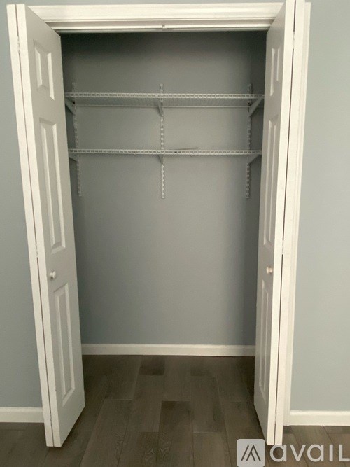 A white closet with shelves and a door open.