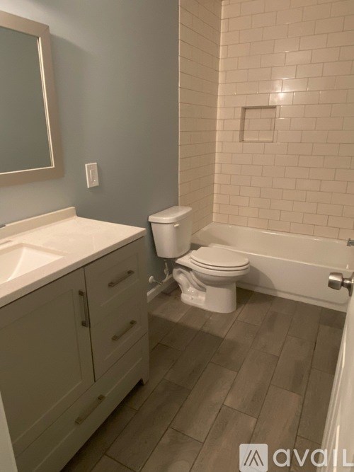 A bathroom with a toilet, sink, and mirror.