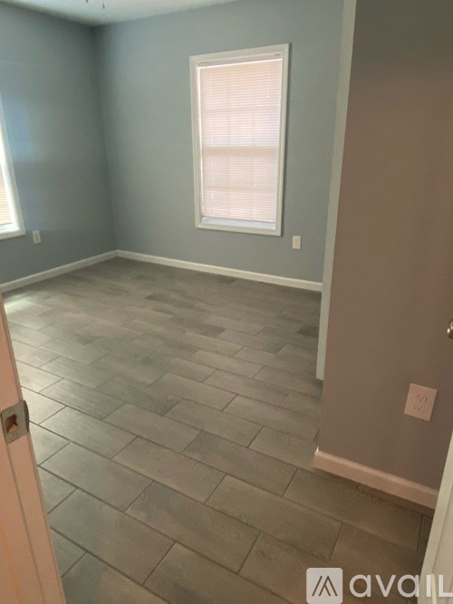 A room with a tile floor and a window with blinds.