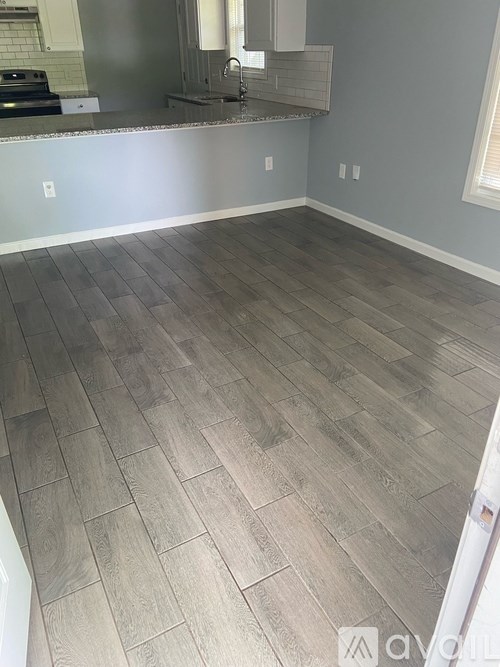 A room with wooden flooring and a white door.