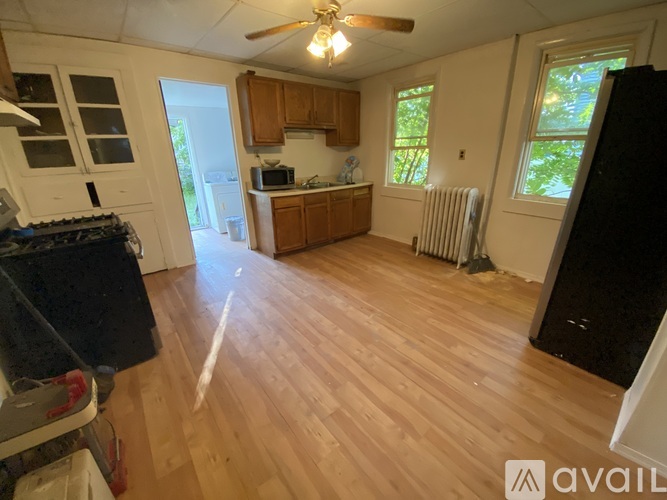 A kitchen with wooden floors and a black refrigerator.