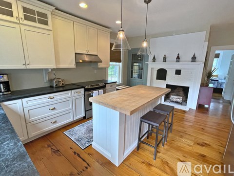 A kitchen with a wooden island and white cabinets.