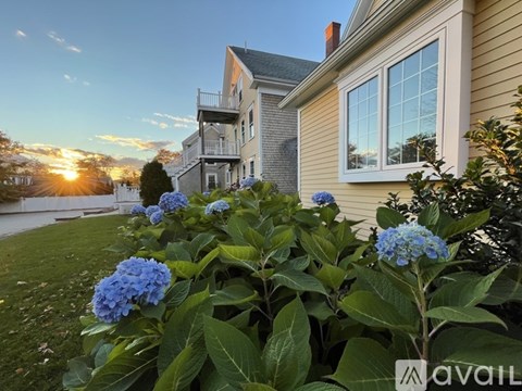 A house with a balcony and a sunset in the background.