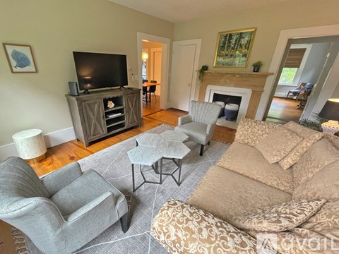 A living room with a grey couch, a white coffee table, and a fireplace.