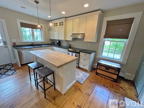 A kitchen with wooden floors and a large island in the middle.