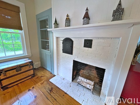 A fireplace with a white mantle and a brick hearth.