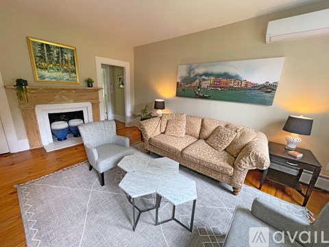 A living room with a fireplace and a painting on the wall.
