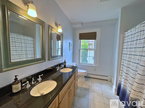 A bathroom with two sinks and a large mirror.
