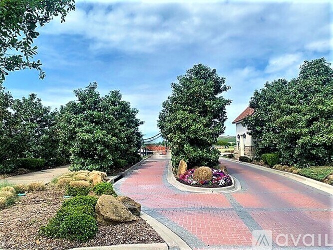 A red brick pathway leads through a landscaped garden.