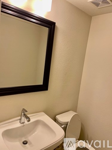 A white sink with a silver faucet and a toilet paper holder in a bathroom.