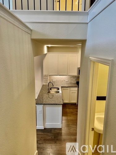 A kitchen with white cabinets and a granite countertop.