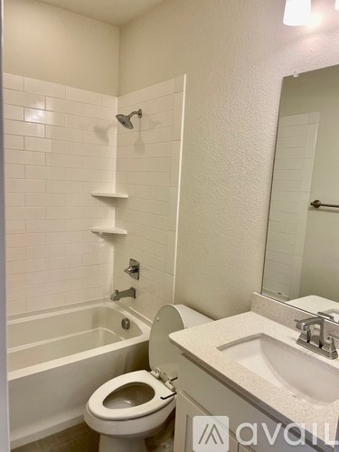 A white bathroom with a toilet, sink, and bathtub.