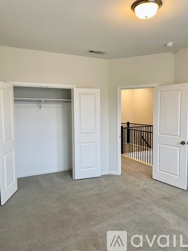 A room with a grey carpet and two white doors.