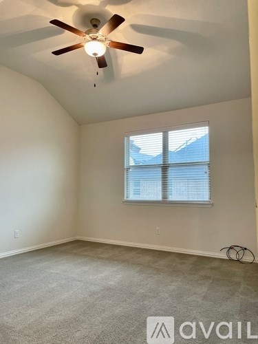 A room with a ceiling fan and a window with blinds.