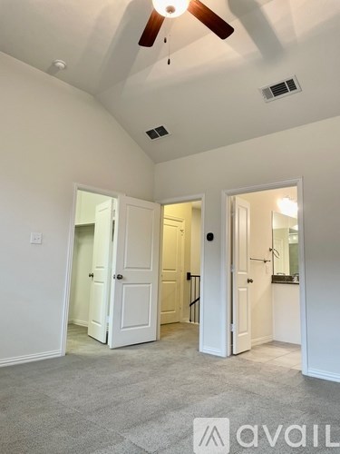 A room with a ceiling fan and a carpeted floor.