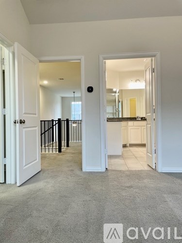A room with a carpeted floor and a doorway leading to another room.