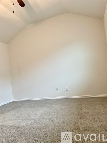 A room with a carpeted floor and a ceiling fan.