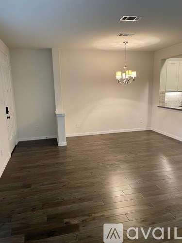 A room with wooden flooring and a chandelier.