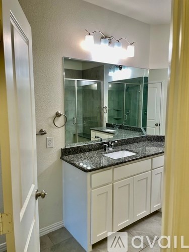 A bathroom with a sink, mirror, and cabinets.