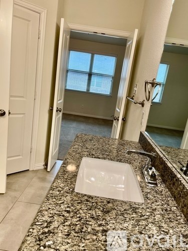 A bathroom with granite countertops and a large mirror.