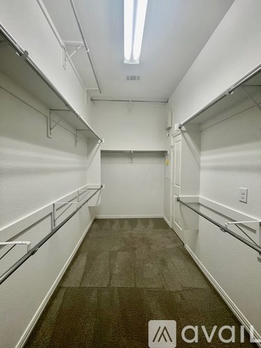 A long hallway with white walls and a carpeted floor.