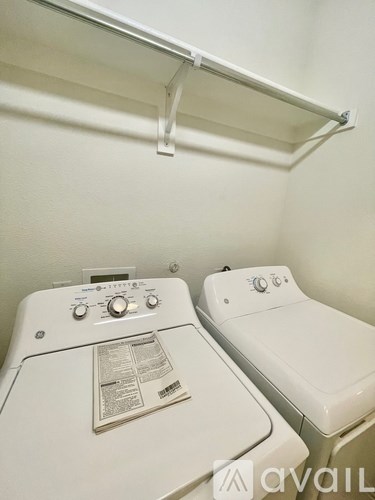 A white washing machine and dryer in a small laundry room.