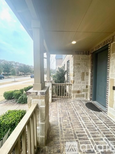 A porch with a green door and a stone wall.