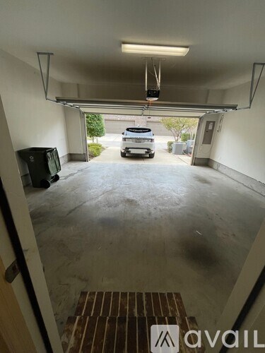 A parking garage with a car parked in the distance and a TV mounted on the wall.