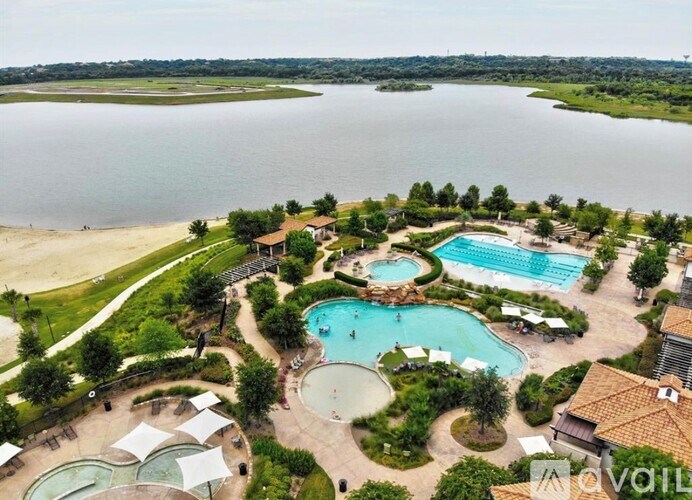 An aerial view of a resort with a large swimming pool and a beach.