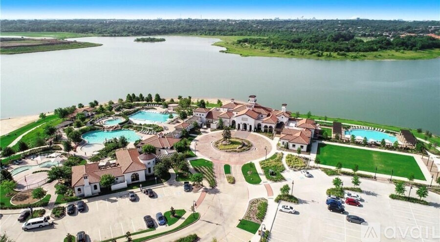 A bird's eye view of a resort with a large swimming pool and a lake in the background.
