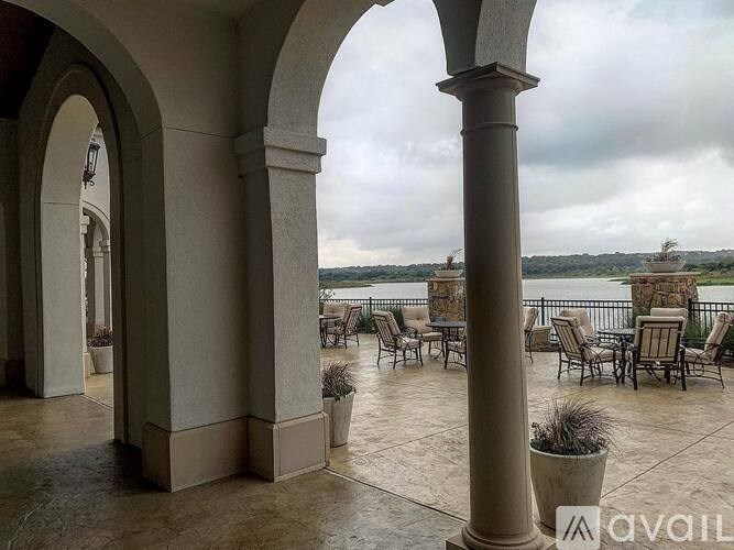 A patio with chairs and a view of the water.