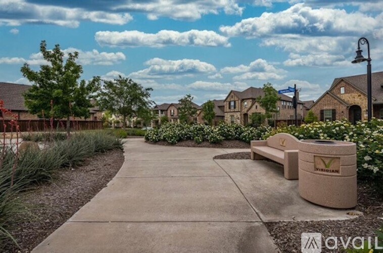 A bench with a logo on it sits in the middle of a sidewalk.
