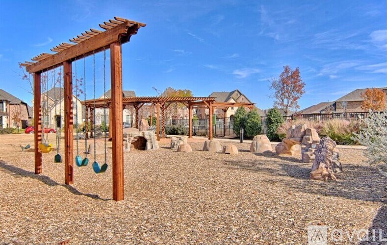 A playground with a swing set and a wooden pergola.