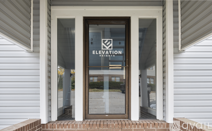 The entrance to a building with a glass door and a sign that reads "Elevation".