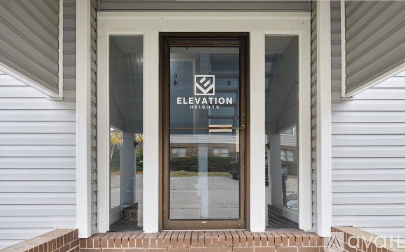 The entrance to a building with a glass door and a sign that reads "Elevation".