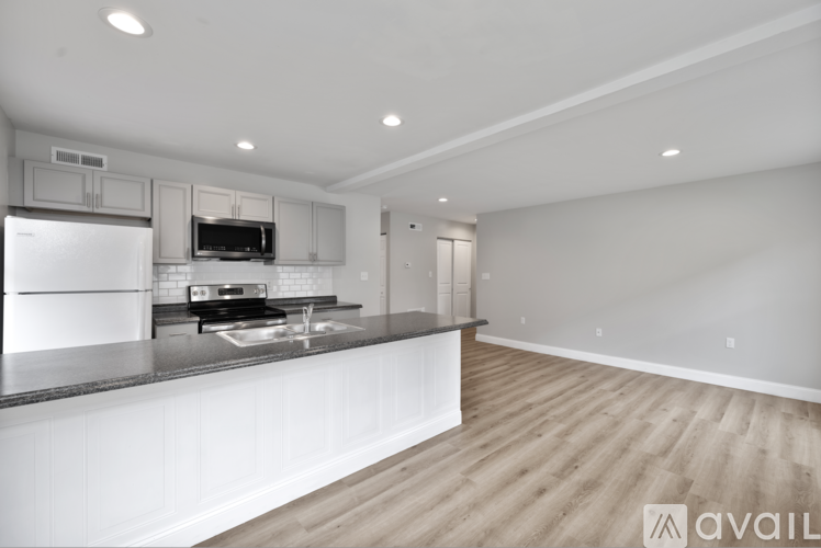 A modern kitchen with a refrigerator, microwave, and oven.