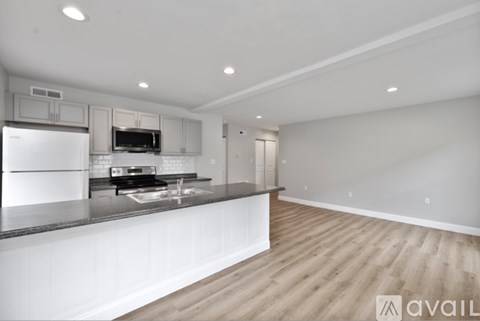 A modern kitchen with a refrigerator, microwave, and oven.